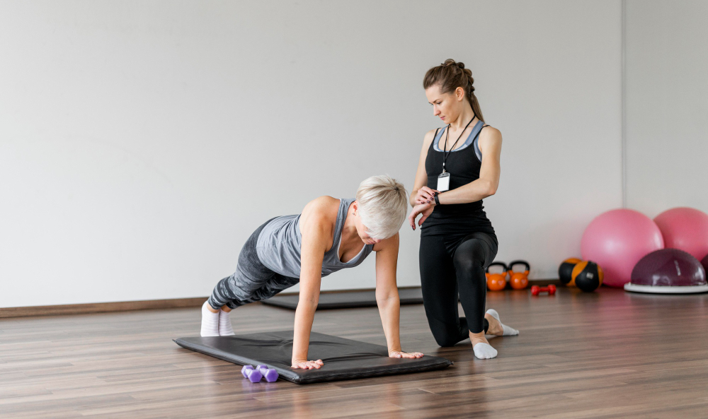 Personal trainer observa mulher fazendo prancha